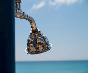 Image showing Reflections in beach shower head by ocean