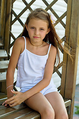 Image showing girl sitting on a wooden bench