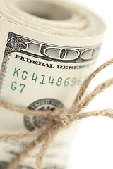 Image showing Roll of One Hundred Dollar Bills Tied in Burlap String on White