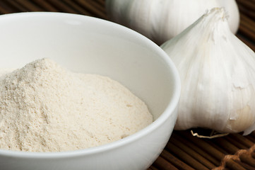 Image showing Crushed garlic powder and whole garlic