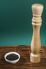 Image showing Bowl with black pepper and wooden pepper mill