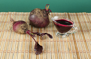 Image showing Red beets with leaves and jug with juice