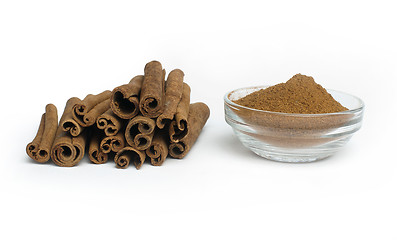 Image showing Powdered cinnamon in bowl and cinnamon sticks