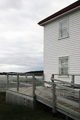 Image showing White weather board building overlooking the ocean