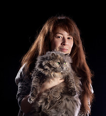 Image showing Young beautiful smiling woman holds fluffy cat