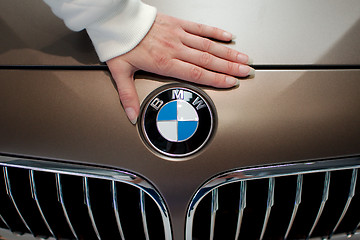 Image showing Woman's hand on BMW logo