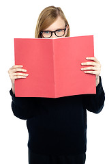 Image showing Student with a red book learning intently