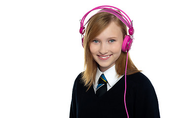 Image showing Cute teenager listening to music through headphones