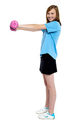 Image showing Pretty teen working out with pink dumbbells