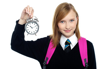 Image showing Pretty charming schoolgirl holding time piece