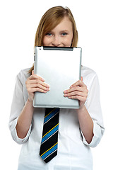 Image showing Shy girl hiding her face with a tablet device