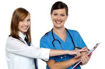 Image showing Attractive girl pointing at the doctors case sheet