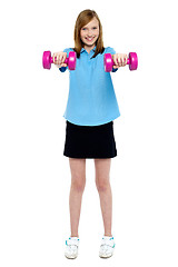 Image showing Slim girl striking a pose with dumbbells. Lifting weights