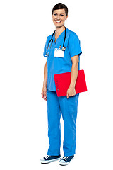Image showing Nurse wearing blue uniform and holding red clipboard