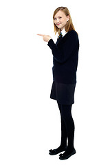 Image showing Student standing sideways and pointing forward