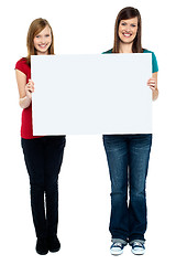 Image showing Pair of good looking women holding whiteboard
