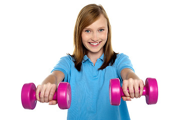 Image showing Adorable teen holding dumbbells in her outstretched arms