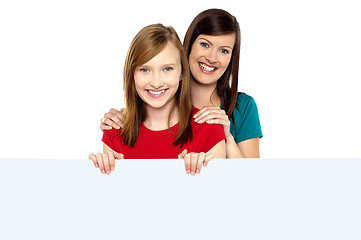 Image showing Girl holding ad board with her mother behind her