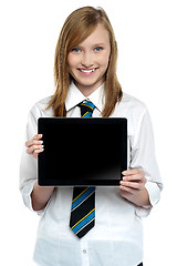 Image showing Pretty college girl displaying a tablet device