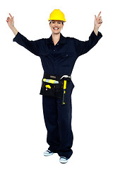 Image showing Smiling lady worker in jumpsuit raising her hands