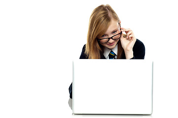 Image showing Girl adjusting her spectacles while working on laptop