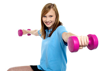 Image showing Cute young girl stretching dumbbells sideways