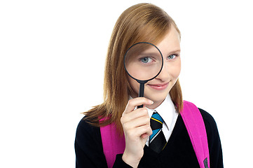 Image showing Teenager looking through a magnifying glass