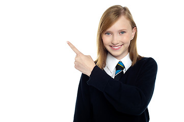 Image showing Calm and relaxed teen girl pointing sideways