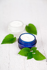 Image showing face cream in jars with urtica leaves