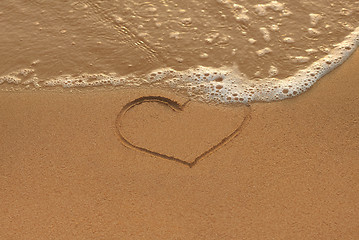 Image showing Heart drawing in the sand on the morning beach