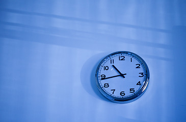 Image showing blue clock on a blue wall