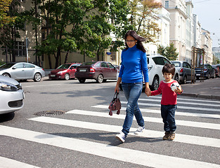 Image showing Mother and son are on a pedestrian crossing in the city