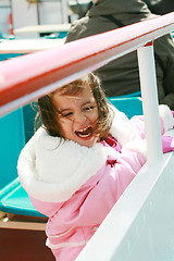 Image showing playful pretty little girl excited recreating in a ride on sail 