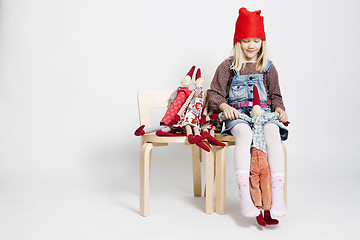 Image showing Happy young girl playing with toy Christmas elf dolls