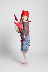 Image showing Happy young girl holding toy Christmas elf doll
