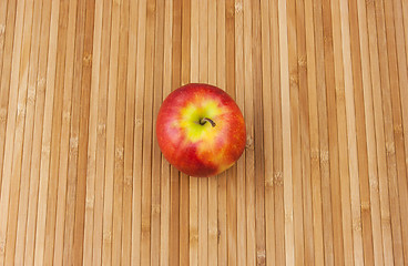 Image showing apple lying on a bamboo napkin