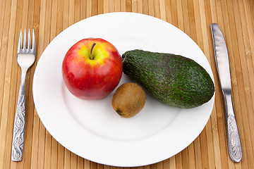 Image showing kiwi, avocado and apple on a plate with cutlery