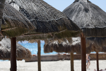 Image showing Straw umbrellas on sandy beach