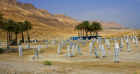 Image showing Stocked chairs in a desert