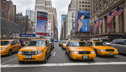 Image showing NEW YORK - MAY 28: Group of yellow taxi cabs rush tourists aroun