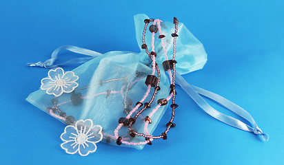 Image showing Beautiful blue silk bag with beaded necklace