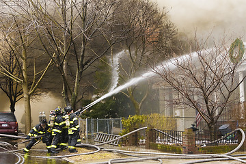 Image showing Firemen at work putting out a house fire