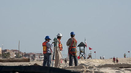 Image showing Constructions working on the beach 