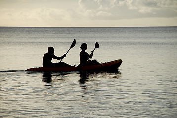 Image showing Man and woman silhouetted at sea in a kayak