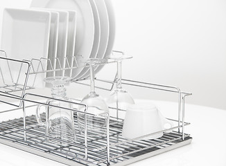 Image showing Dishes and glasses drying on metal dish rack