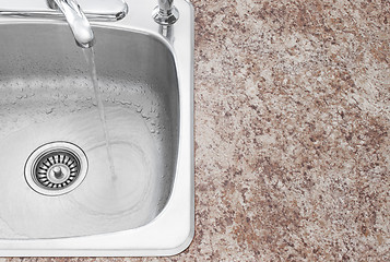 Image showing Water running from kitchen faucet and countertop detail