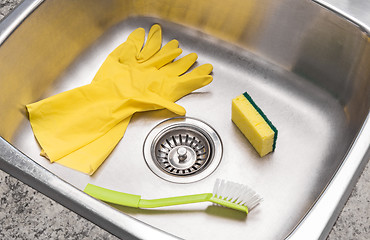 Image showing Gloves, sponge and brush in a clean kitchen sink