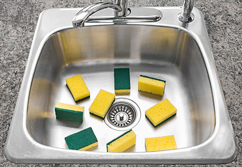 Image showing Lots of yellow sponges in a clean kitchen sink