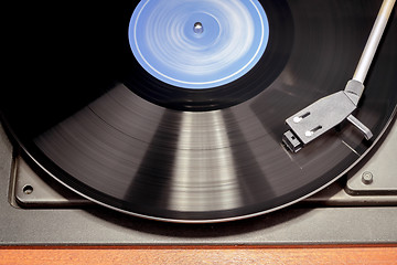 Image showing Vintage record player with spinning vinyl. Motion blur image. 