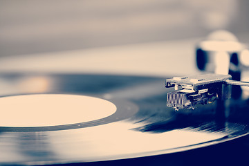 Image showing Spinning vinyl record. Motion blur image.  Vintage toned. 